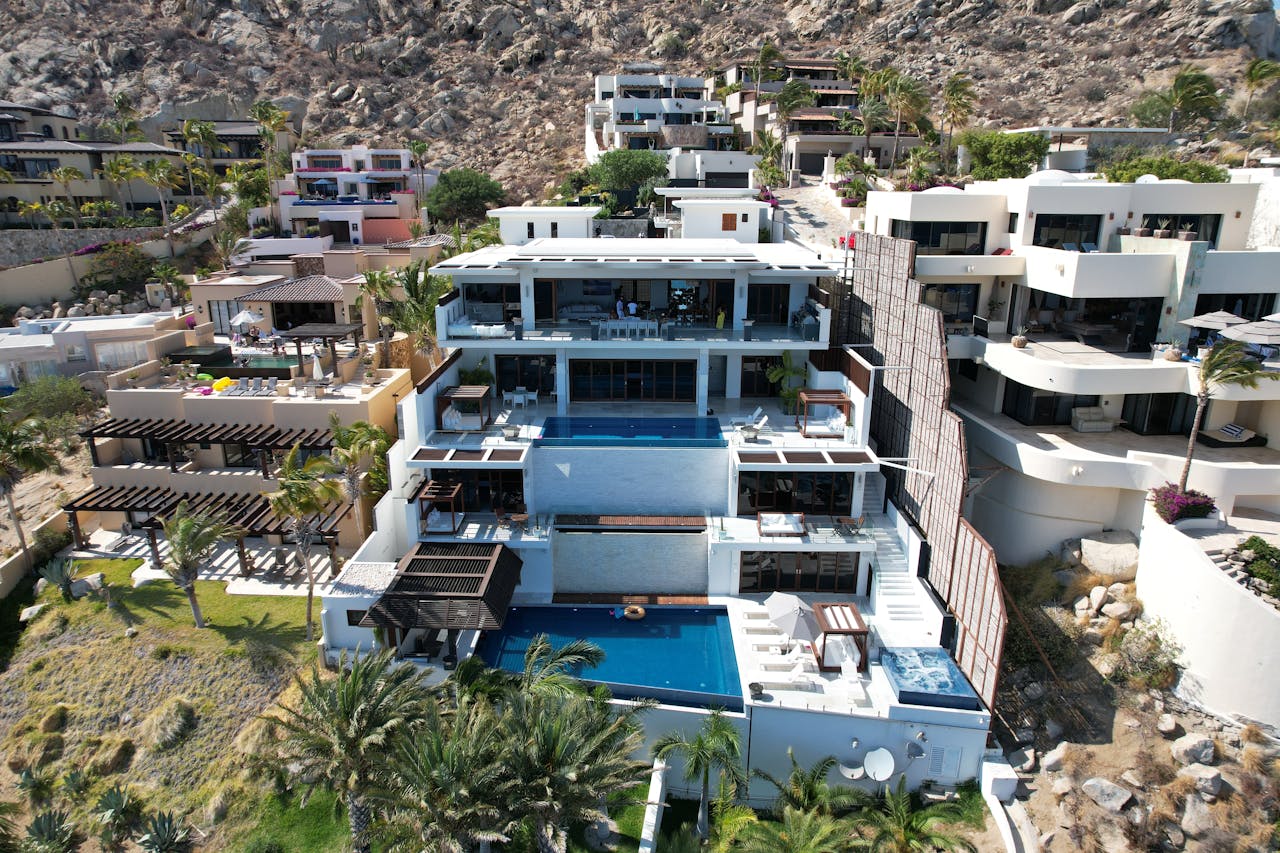 heros-img Aerial view of stunning modern villas in Cabo San Lucas with ocean views.