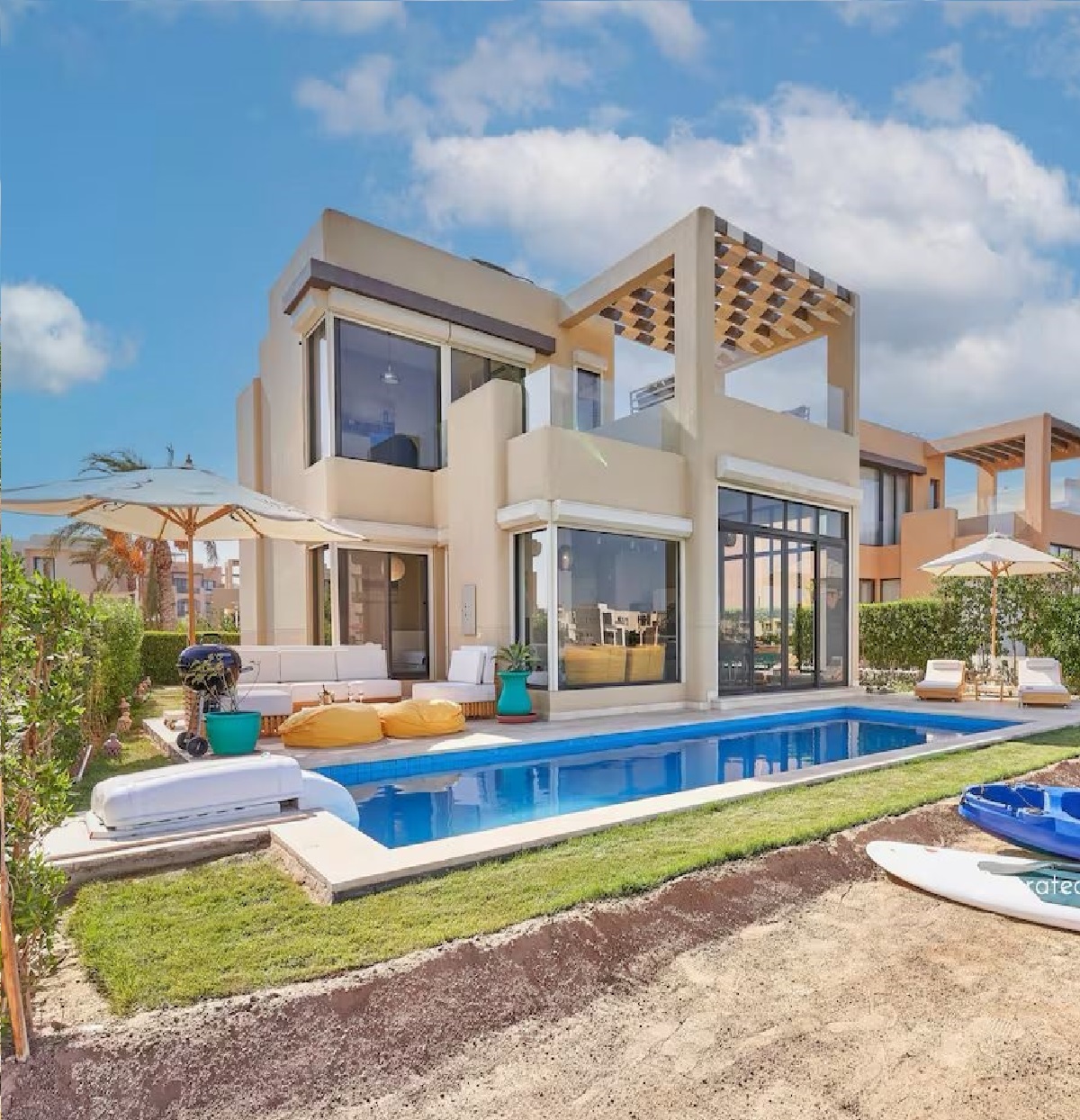 about-us A contemporary building showcasing geometric design and wooden accents against a clear blue sky.